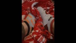 Tiny feet in mix match socks rubbing blanket