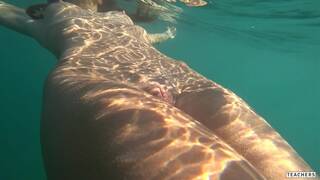 Nude model swims on a public beach in Russia