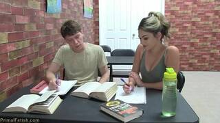 Alex C and Athena F next to & also on a grey coloured sofa in lesbian vampire scenes