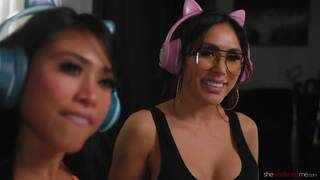 Ember Snow and Jena Larose on a black coloured leather sofa in a lesbian scene