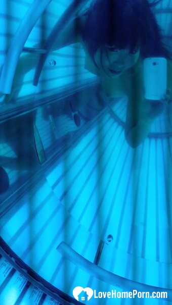 Asian sweetie taking selfies while tanning her body