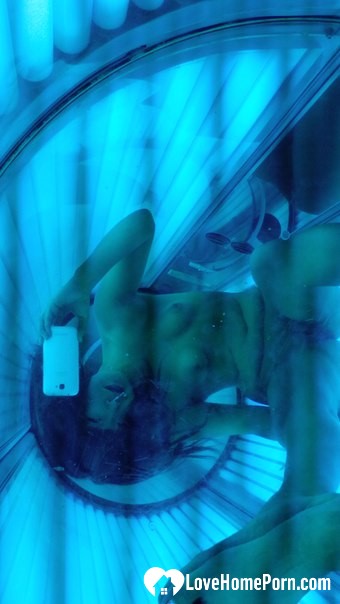 Asian sweetie taking selfies while tanning her body