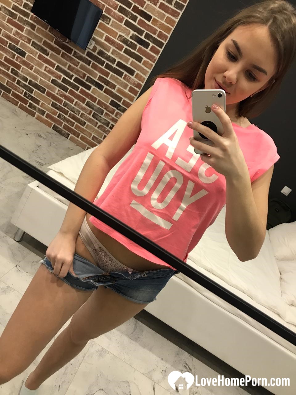 Horny teen plays with her phone while flashing