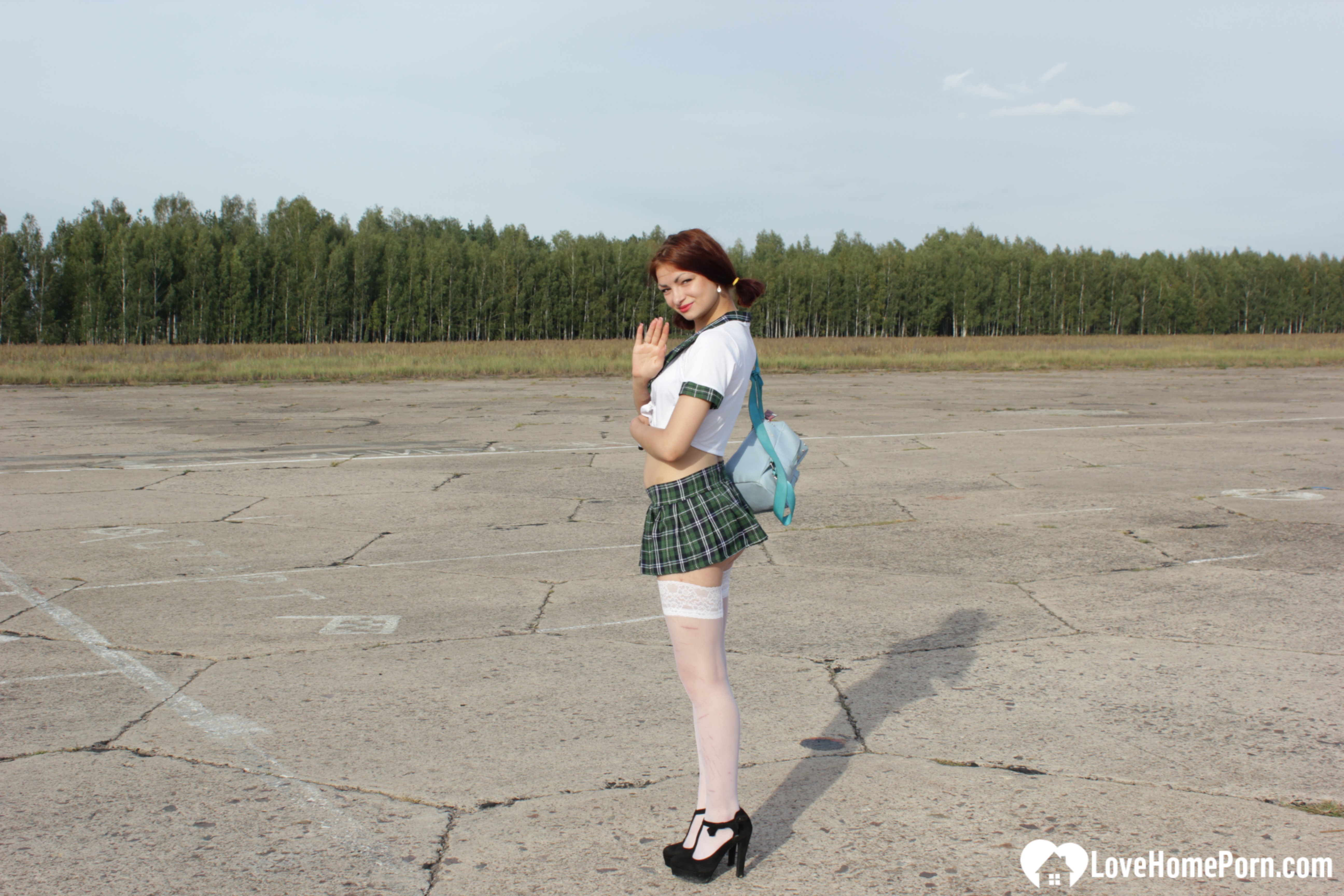 Incredible mom in a schoolgirl outfit posing outdoors